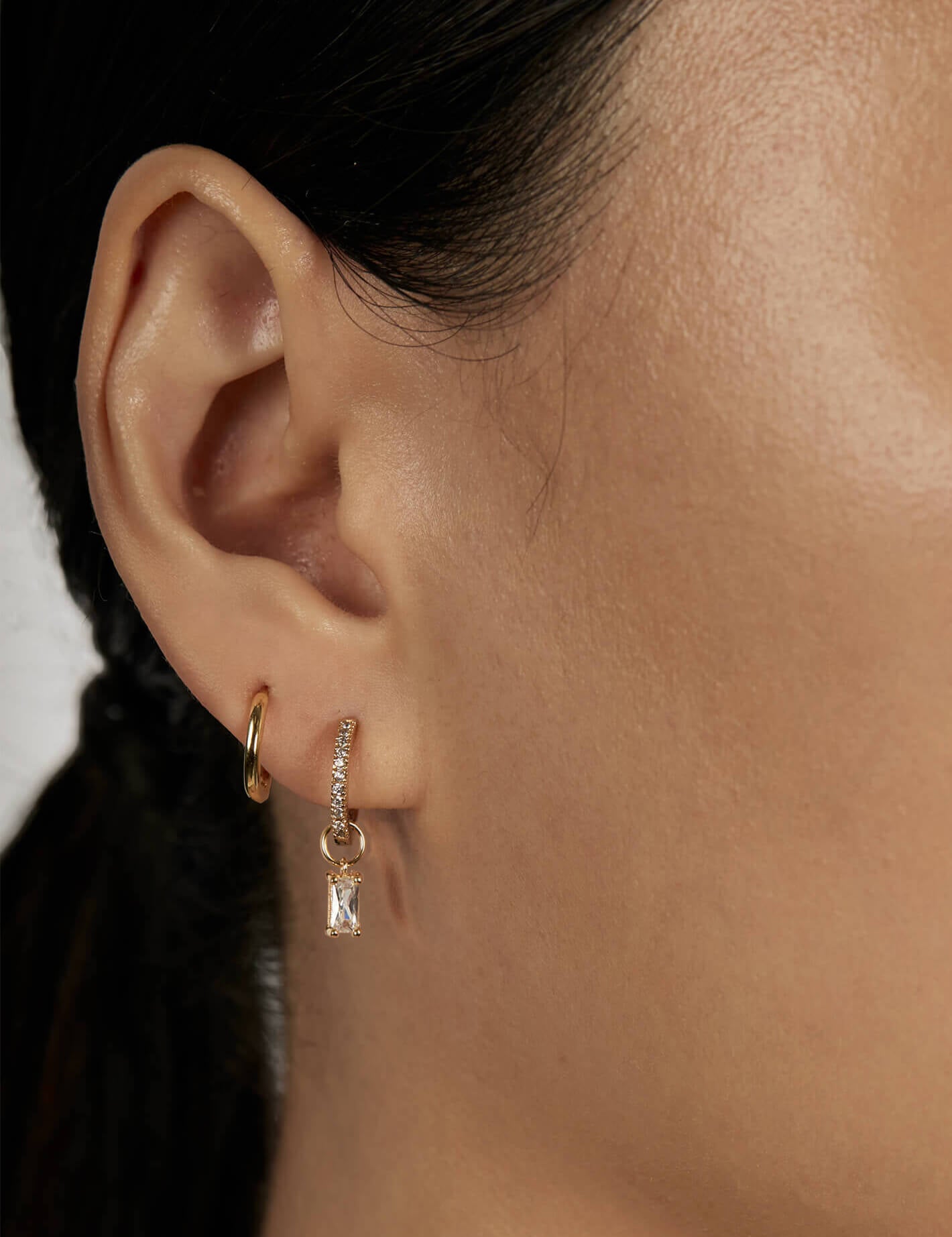 Baguette Huggie Charms with stacked huggie earrings closed-up view
