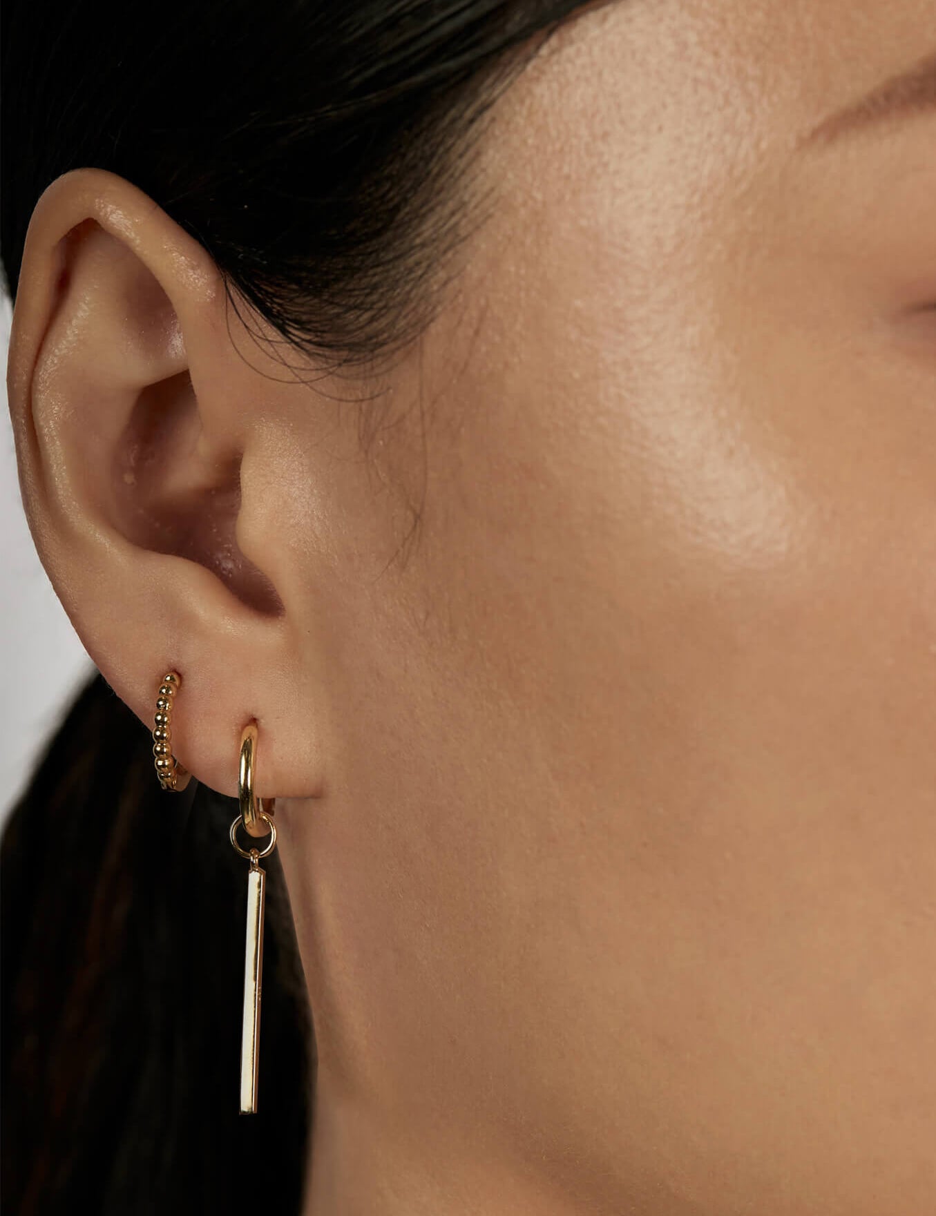 Linear Huggie Charms with stacked huggie earrings close-up view