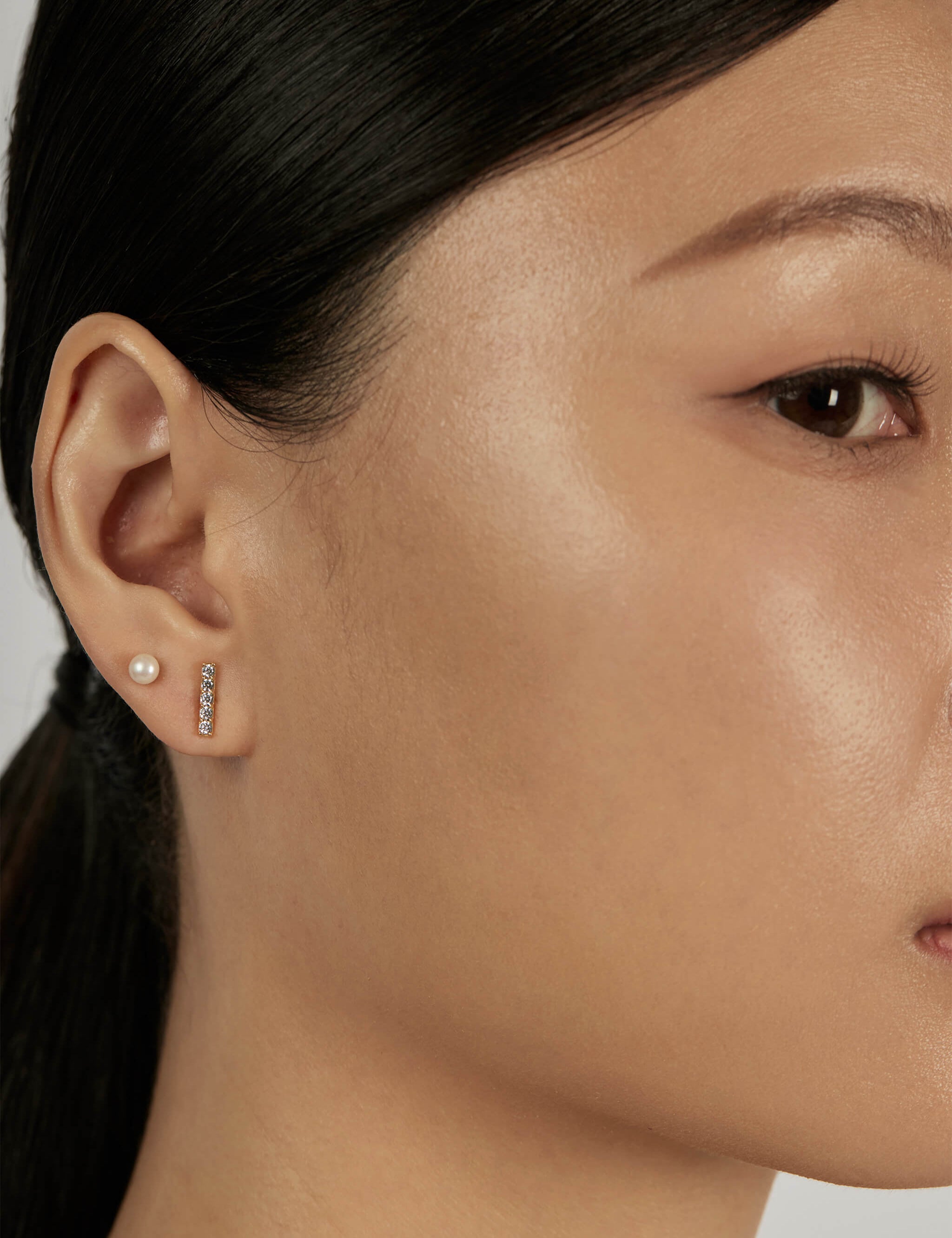 Pearl Stud Earrings styled in a layered ear stack