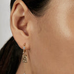 Solitaire Huggie Earrings with stacked charms closed-up view