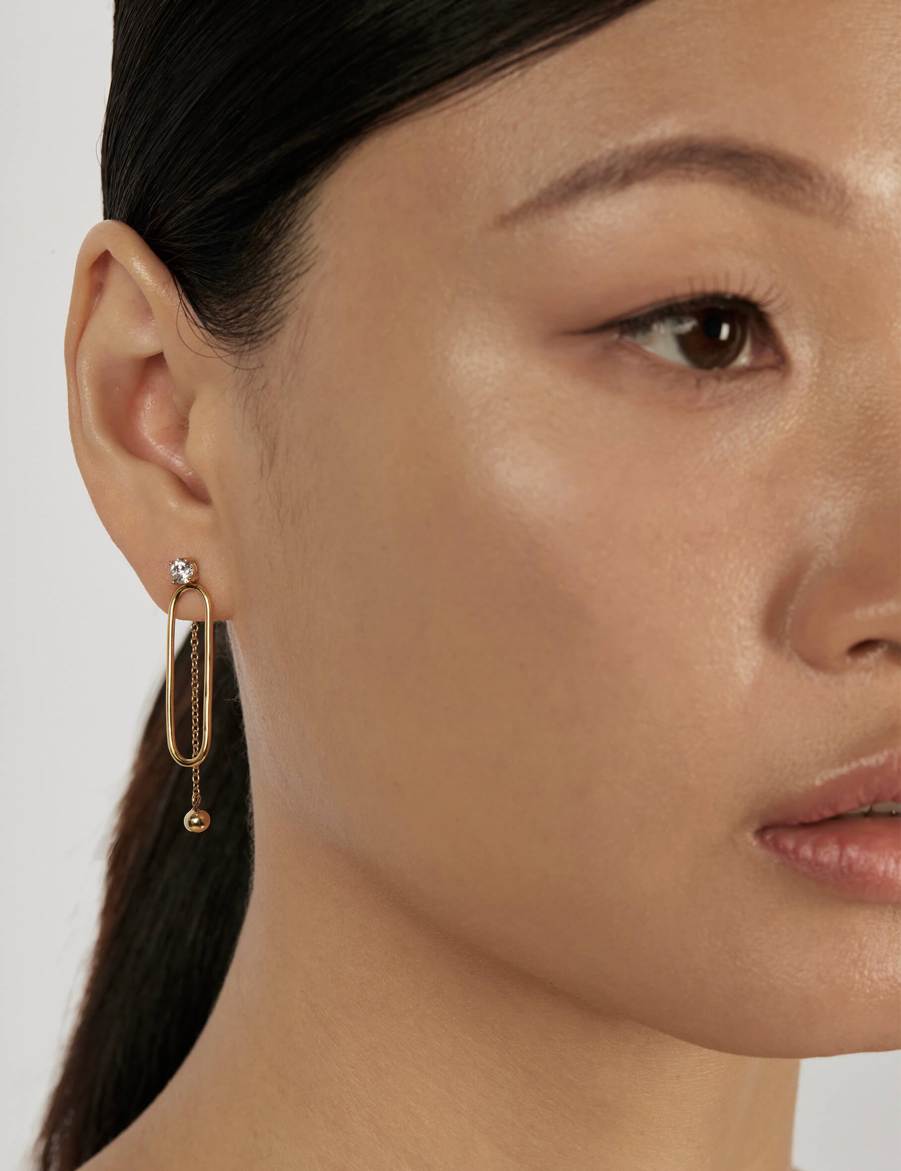 Solitaire Stud Earrings styled in a layered earring stack